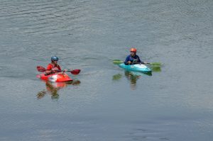 2 person riding on kayak on body of water during daytime