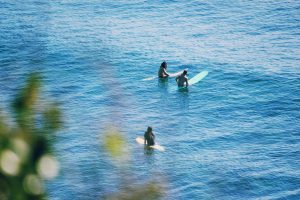 2 people surfing on blue sea during daytime